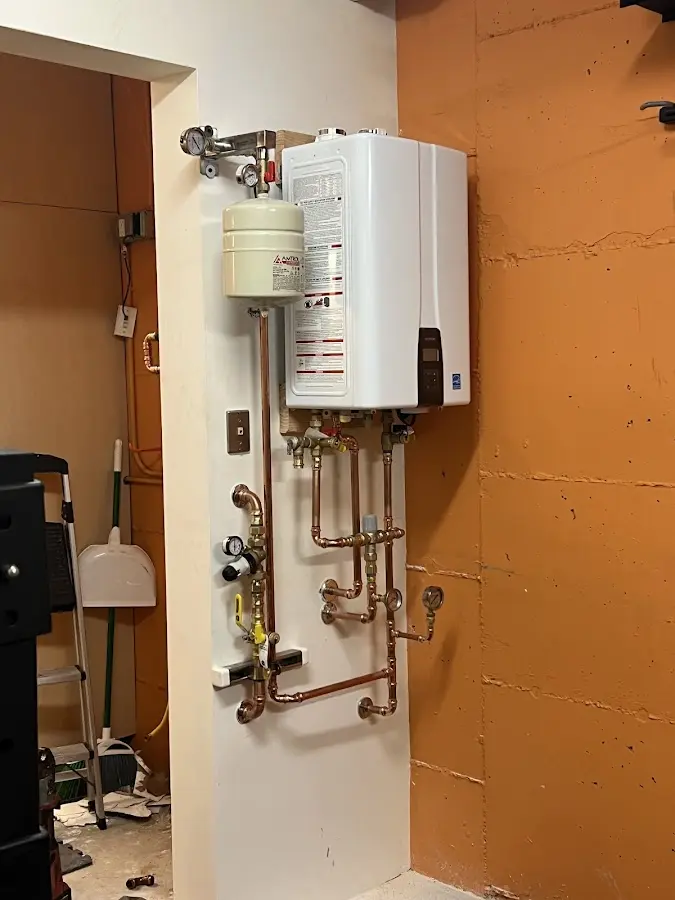 Plumbing technician inspecting water heater connections in Signal Mountain